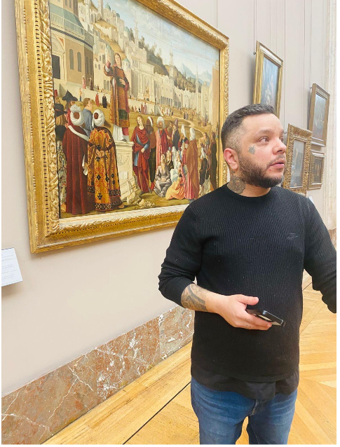 Rodrigo Cezary observando uma obra de arte em um museu